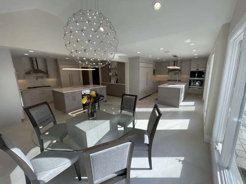 Open-plan kitchen with twin islands, sphere chandelier and dining area