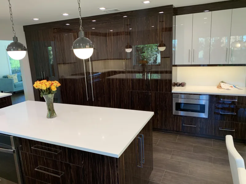 High-gloss walnut kitchen with white quartz waterfall island