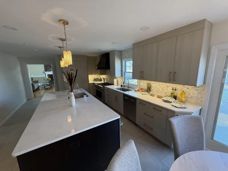 Taupe kitchen with mosaic backsplash and gold pendants